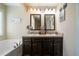 Bathroom features a double sink vanity with dark wood cabinets, chrome fixtures, and a soaking tub at 338 Rc Thompson Rd, Dallas, GA 30157