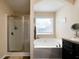 Clean bathroom featuring a glass enclosed shower, soaking tub, and dark wood cabinets at 338 Rc Thompson Rd, Dallas, GA 30157