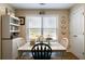 Cozy dining area with bright window, decorative shelving, and a charming table set for a meal at 338 Rc Thompson Rd, Dallas, GA 30157