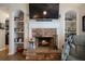 Living room fireplace with stone surround, custom shelving, and wood flooring at 338 Rc Thompson Rd, Dallas, GA 30157
