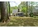 Spacious backyard featuring mature trees, a screened porch, and play area at 5215 Silver Creek Dr, Lilburn, GA 30047