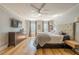 Bedroom features hardwood floors, tv, windows, ceiling fan, and neutral color palette at 5215 Silver Creek Dr, Lilburn, GA 30047