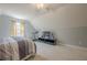 This attic bedroom features neutral paint and carpet with a striped bed, treadmill, and TV area at 5215 Silver Creek Dr, Lilburn, GA 30047