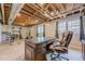 Home gym featuring exposed ceilings, a standard desk, various exercise equipment, and large windows at 5215 Silver Creek Dr, Lilburn, GA 30047