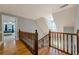 Upstairs hallway with hardwood floors, staircase, natural light, and blue wall accents at 5215 Silver Creek Dr, Lilburn, GA 30047