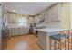 Bright kitchen features stainless steel appliances, light gray cabinets, tile backsplash, and modern breakfast bar at 5215 Silver Creek Dr, Lilburn, GA 30047