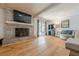 Living room with brick fireplace, hardwood floors, large windows, and access to outdoor patio at 5215 Silver Creek Dr, Lilburn, GA 30047