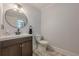 Stylish powder room with modern fixtures, vanity sink, round mirror, and tiled flooring at 5215 Silver Creek Dr, Lilburn, GA 30047