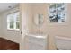 Bright bathroom featuring a round mirror and a vanity with white marble countertop at 811 Ponce De Leon Ne Pl, Atlanta, GA 30306