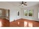 Well lit empty room with hardwood floors, white walls, a ceiling fan and natural light from large windows at 811 Ponce De Leon Ne Pl, Atlanta, GA 30306
