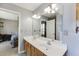Bathroom featuring a double sink vanity, light blue walls, and a mirror at 1545 Smoke Hill Dr, Hoschton, GA 30548