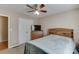 Bedroom with a ceiling fan, double door closet, light brown walls and carpet, and a wooden bed frame at 1545 Smoke Hill Dr, Hoschton, GA 30548