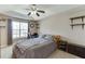 Bedroom with a ceiling fan, light brown walls and carpet, decorative shelving, and a large window at 1545 Smoke Hill Dr, Hoschton, GA 30548