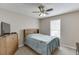Bedroom featuring a ceiling fan, window, light brown walls and carpet, and a wooden bed frame at 1545 Smoke Hill Dr, Hoschton, GA 30548