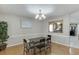 Bright dining room with hardwood floors, modern chandelier, and seamless flow to the kitchen at 1545 Smoke Hill Dr, Hoschton, GA 30548