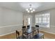 Well-lit dining room with hardwood floors, modern light fixture, and view of the outdoor patio at 1545 Smoke Hill Dr, Hoschton, GA 30548
