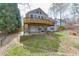 Exterior house view from backyard featuring wooden deck, porch, and spacious grassy yard at 1545 Smoke Hill Dr, Hoschton, GA 30548