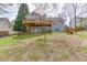 Exterior house view from backyard featuring wooden deck, porch, spacious grassy yard, and blossoming tree at 1545 Smoke Hill Dr, Hoschton, GA 30548