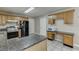 Charming kitchen with wood cabinets, granite countertops, black appliances and breakfast nook at 1545 Smoke Hill Dr, Hoschton, GA 30548