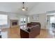 Bright living room featuring hardwood floors, vaulted ceiling, and a cozy brick fireplace at 1545 Smoke Hill Dr, Hoschton, GA 30548