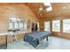 Bright sunroom features wood paneling, skylights, and a pool table for entertaining at 1545 Smoke Hill Dr, Hoschton, GA 30548