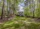 Spacious backyard with green lawn and mature trees, providing a picturesque and private outdoor setting at 11770 Ashwick Pl, Johns Creek, GA 30005