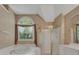 An elegant bathroom featuring a soaking tub, walk-in shower, and decorative wallpaper at 11770 Ashwick Pl, Johns Creek, GA 30005