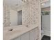Double sink bathroom with floral wallpaper and tiled shower/tub at 11770 Ashwick Pl, Johns Creek, GA 30005