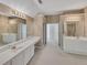 Large bathroom featuring dual sinks, vanity, and multiple mirrors at 11770 Ashwick Pl, Johns Creek, GA 30005
