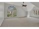 A bright, airy bedroom featuring a large arch window and ceiling fan at 11770 Ashwick Pl, Johns Creek, GA 30005