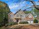 Beautiful two-story home featuring a mix of brick and stucco exterior, lush landscaping, and a driveway at 11770 Ashwick Pl, Johns Creek, GA 30005