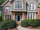 Elegant front entrance with a charming doorway, decorative shrubbery, and manicured bushes at 11770 Ashwick Pl, Johns Creek, GA 30005