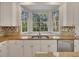 Kitchen featuring a bay window, granite countertops, white cabinets, and stainless steel dishwasher at 11770 Ashwick Pl, Johns Creek, GA 30005