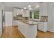 Open kitchen showcasing a center island, granite countertops, and hardwood floors at 11770 Ashwick Pl, Johns Creek, GA 30005