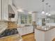 Well-lit kitchen boasts granite countertops, stainless steel appliances, and a stylish backsplash at 11770 Ashwick Pl, Johns Creek, GA 30005