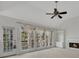 Living room with fireplace, built-in bookshelves, and windows with curtains overlooking a deck at 11770 Ashwick Pl, Johns Creek, GA 30005