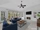 Staged living room with a fireplace, built-in bookshelves, large windows, and comfortable seating at 11770 Ashwick Pl, Johns Creek, GA 30005
