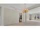 Bright Living room featuring a column, chandelier, and view into the kitchen at 11770 Ashwick Pl, Johns Creek, GA 30005