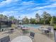 Community pool with lounge chairs and tables for relaxing poolside, adjacent to a clubhouse at 11770 Ashwick Pl, Johns Creek, GA 30005
