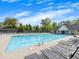 Community pool with lounge chairs for relaxing poolside, next to a clubhouse and mature trees at 11770 Ashwick Pl, Johns Creek, GA 30005