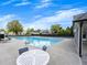 Community pool with lounge chairs and tables for relaxing poolside, with lush landscaping at 11770 Ashwick Pl, Johns Creek, GA 30005