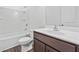 Bathroom features a shower over tub, wooden cabinet, vinyl flooring, and a sink at 1512 Parks Edge Nw Ln, Atlanta, GA 30318