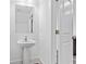 A pedestal sink in a bathroom adjacent to an open door and mirror at 1512 Parks Edge Nw Ln, Atlanta, GA 30318