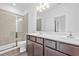 A bathroom with double sinks, walk-in shower, and dark wood cabinets at 1512 Parks Edge Nw Ln, Atlanta, GA 30318