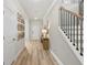 Inviting hallway with wood floors, staircase, and decorative wall art at 5260 Trescott Path, Cumming, GA 30028