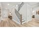 Spacious hallway featuring a staircase with black railings and access to other rooms at 5260 Trescott Path, Cumming, GA 30028