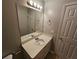 Bathroom featuring a vanity sink, a mirror with lighting, and a white door at 5922 Graywood Cir, Mableton, GA 30126