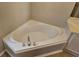 Bright bathroom featuring a corner soaking tub with chrome fixtures at 5922 Graywood Cir, Mableton, GA 30126