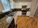 Close-up of the kitchen featuring a stainless steel range, black backsplash, and granite countertops at 5922 Graywood Cir, Mableton, GA 30126