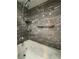 Modern bathroom with jacuzzi tub, sleek fixtures, and marble-look tiled walls at 2220 Wellington Cir, Lithonia, GA 30058